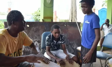 a traditional drum workshop a tutor showing a student some rudiments to playing the drum