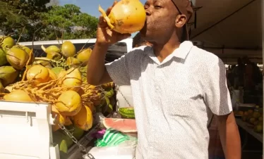 a visitor drinking a coconut water in port of spain