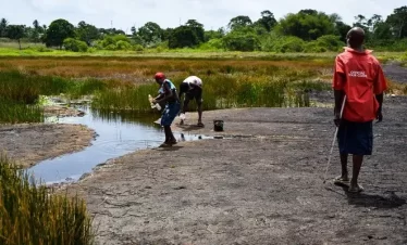 Villagers fetch sulphur water from the pitch lake in la brea, trinidad.