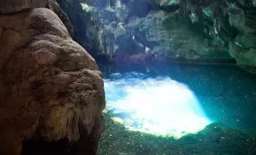 A clear pool of 30 feet in diameter at the Blue Grotto which reflects the sunlight that streams through a hole at the top of the cave.