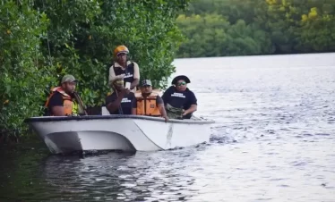 Caroni Swamp police and game wardens watching the proceedings as the birds fly in.
