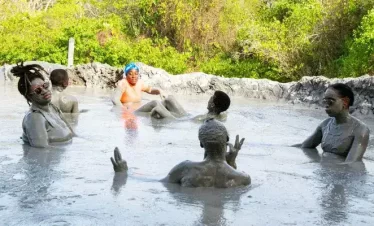people soaking in a natural pool of volcanic mud.