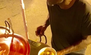 A vendor serving con soup in port of spain, trinidad