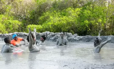 people soaking in a natural pool of volcanic mud.