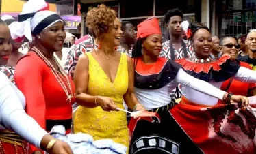 a group of traditional dancers takes janelle "penny" commissiong through some traditional dance moves