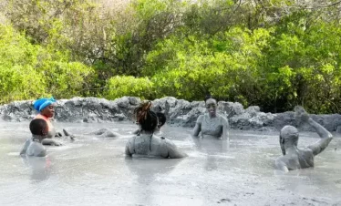 people soaking in a natural pool of volcanic mud.