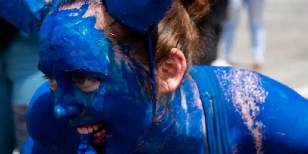 a caucasian female experiencing the eccentric qualities of the "blue-devil" character in trinidad.