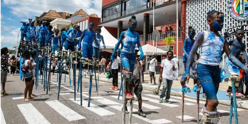 children experience the unique feelings of the moko jumbies, walking on stilts in the kiddies carnival in trinidad.