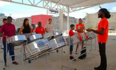 a tutor at the trini riddims cultural tours go through some playing excercises with a steelpan workshop
