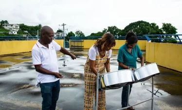 Two local celebrities take a lesson on the steelpan